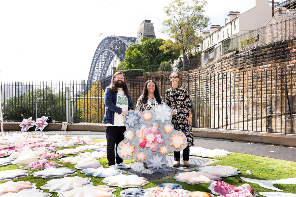 Aunty Lola Ryan with Nathan Mudyi Sentance (Head of Collections, First Nations) and Tammi Gissell (Collections Coordinator, First Nations) holding a shell from
Ngabu; Walsh Bay, Sydney; photo: Powerhouse Museum

This project is proudly funded by the NSW Government's Community Improvement District Pilot Program and Uptown Grant Program.